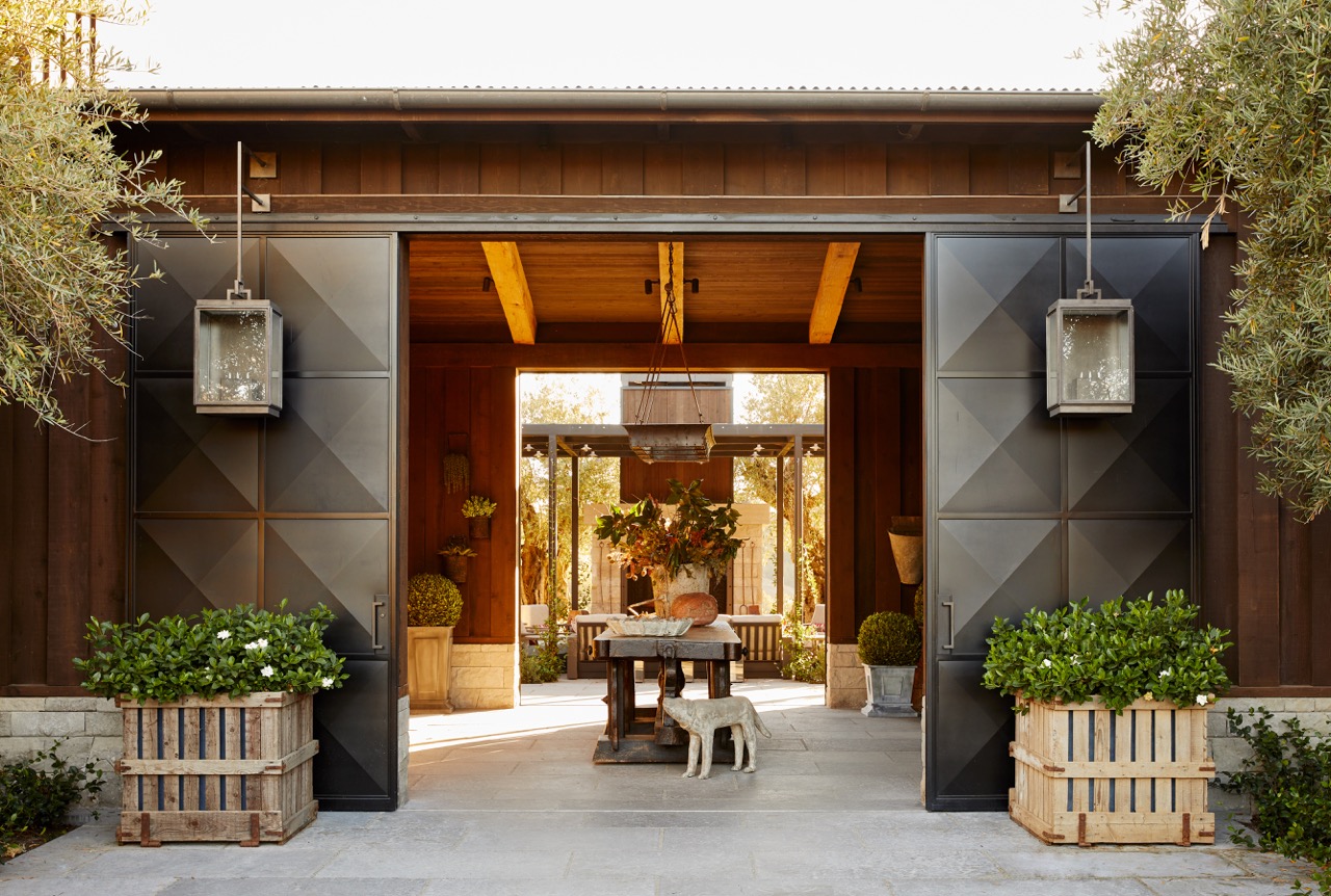 The dramatic vestibule entry sets the tone for the home with its sliding steel doors, antique treasures and palette of natural materials such as limestone and weathered wood. Photos by John Merkl.