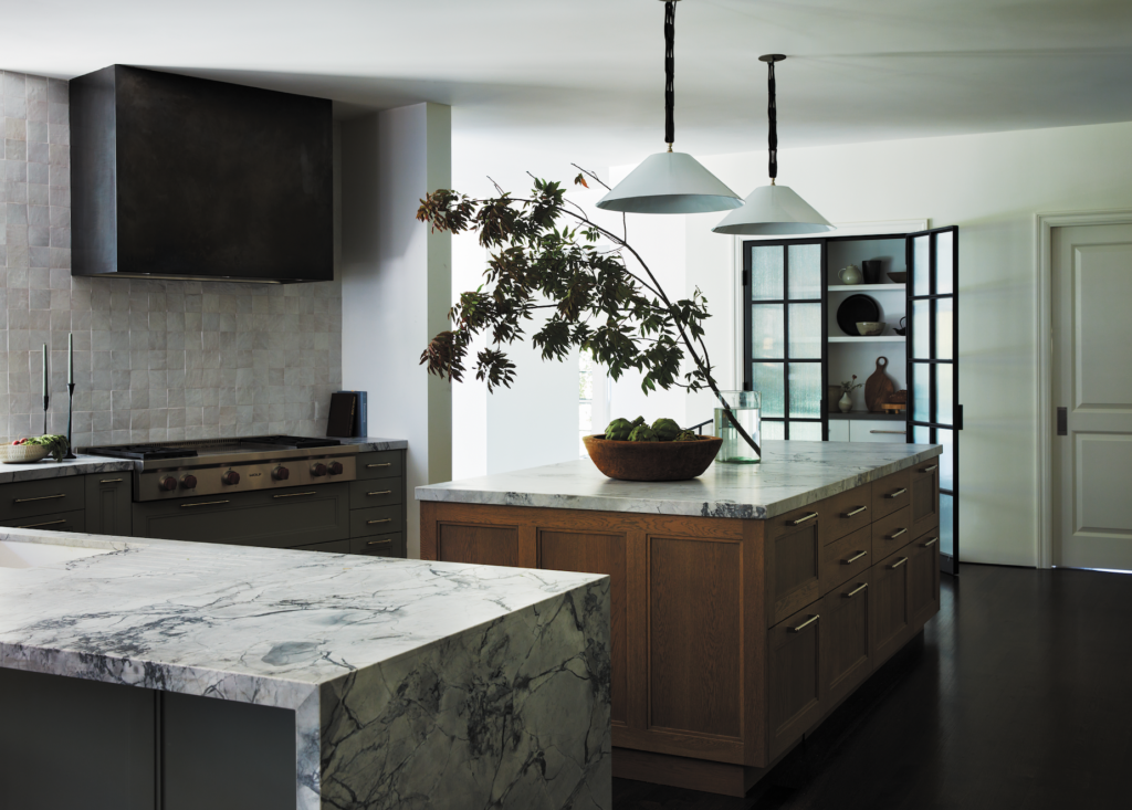 The kitchen deftly combines traditional features, like an oak island and floors stained a medium-brown tone, with modern elements such as the custom bronze hood. Photos by Tim Lenz.